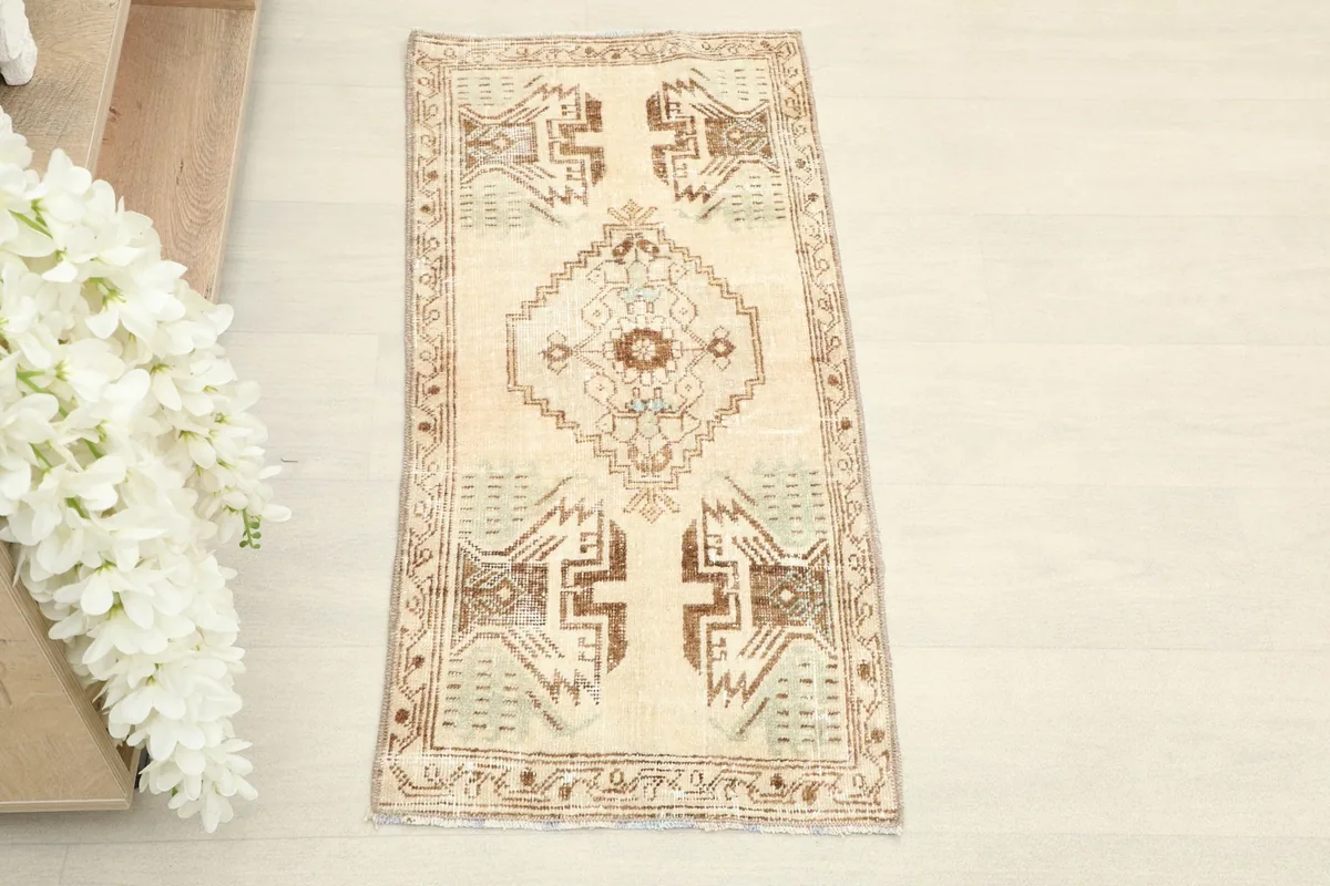 Overhead view of the hand-knotted beige doormat, showcasing its central medallion and geometric patterns.