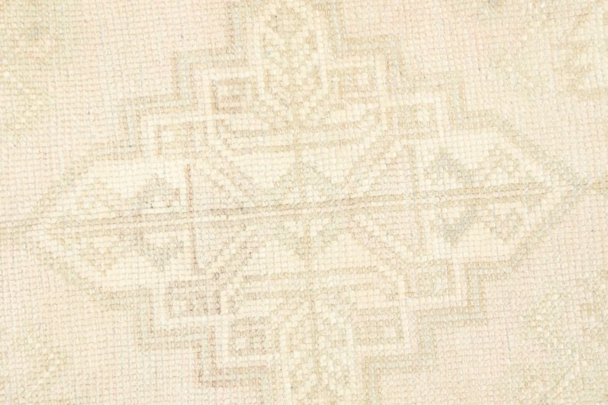 Detailed view of the central geometric motif and texture of the wool pile.