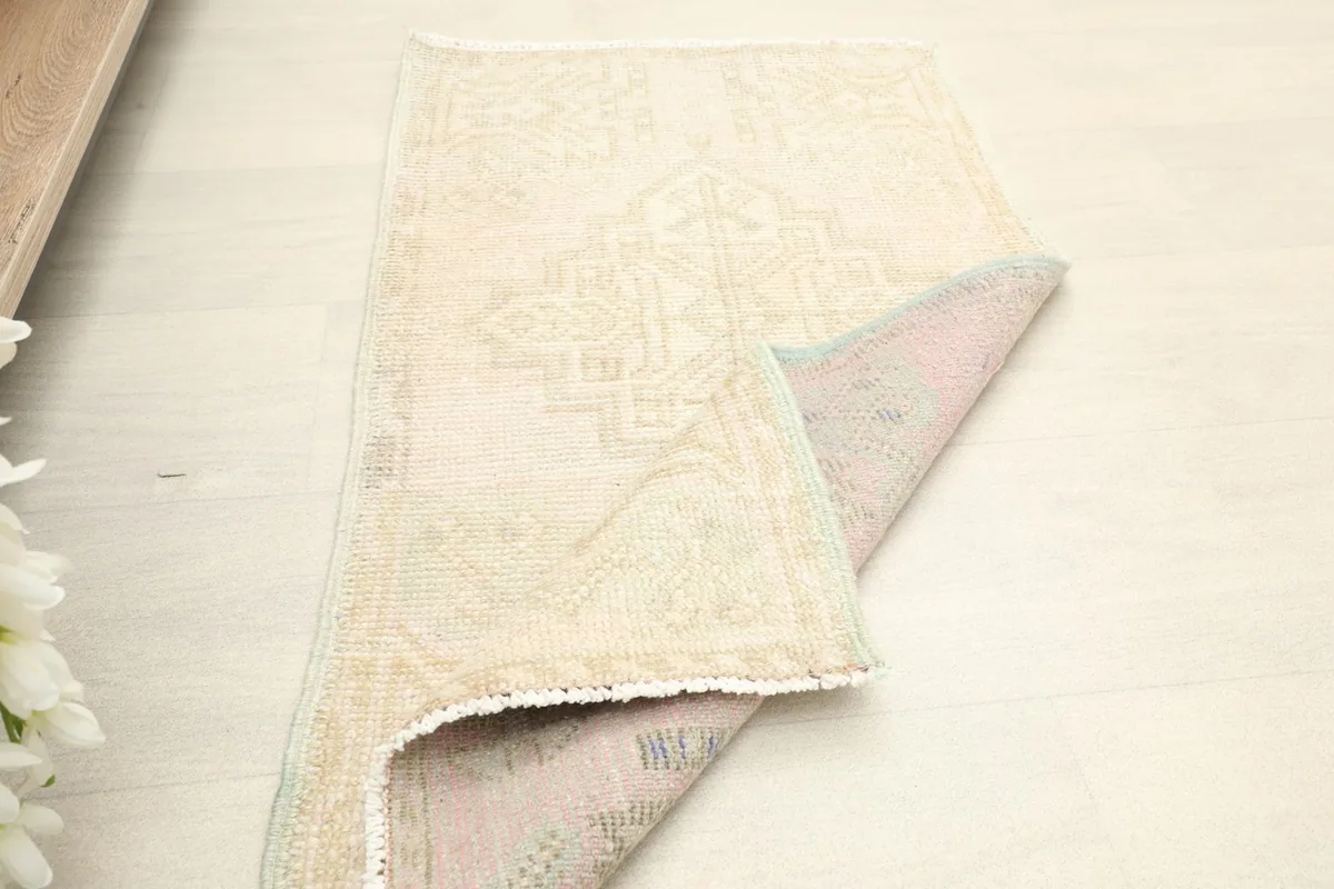 The vintage rug partially folded, displaying both the front and back textures.