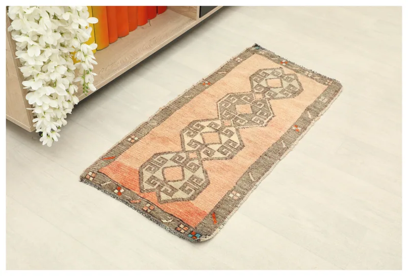 Full top view of the 1'6" x 3'1" vintage orange and gray geometric Anatolian rug on a white floor.