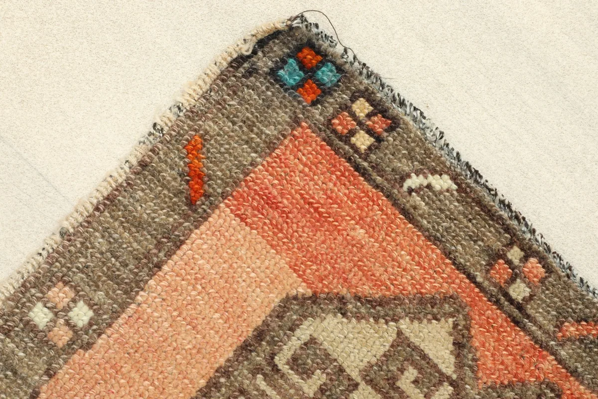 Corner detail showing the gray border, orange field, and subtle accent colors in the pattern.