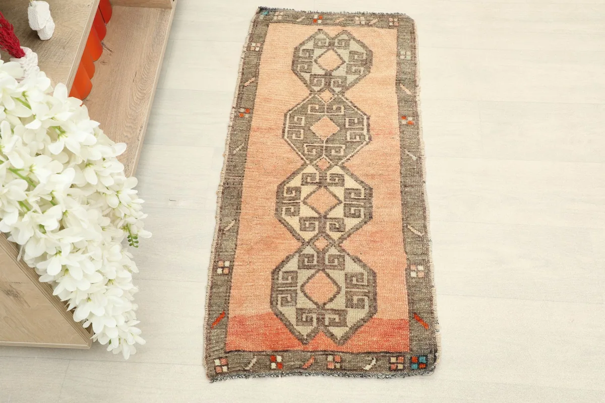 Overhead view showcasing the orange field and gray geometric chain pattern of the Anatolian rug.