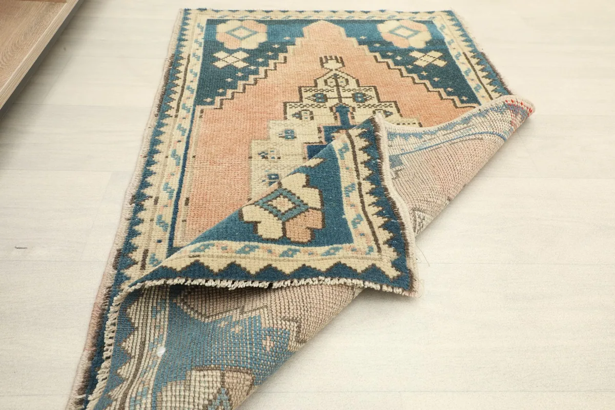 Rug partially folded, revealing the reverse side and the hand-knotted construction