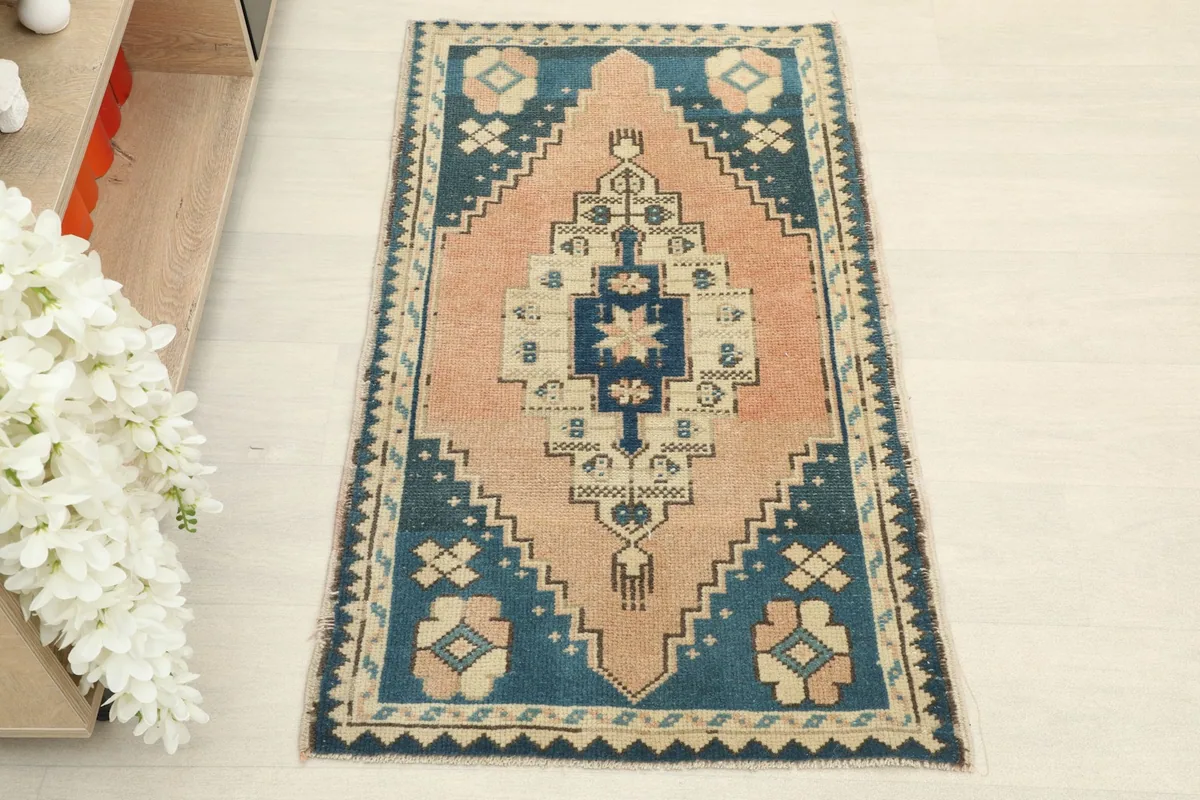 Overhead view of the hand-knotted wool rug, highlighting its rose field and blue border