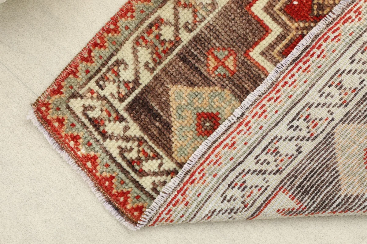 View of the rug folded to reveal the backside and the hand-knotted wool pile texture.