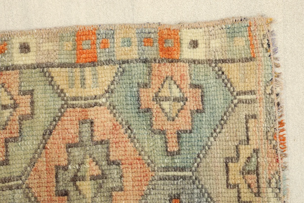 Close-up of the rug's edge, displaying the border pattern and the hand-finished sides.