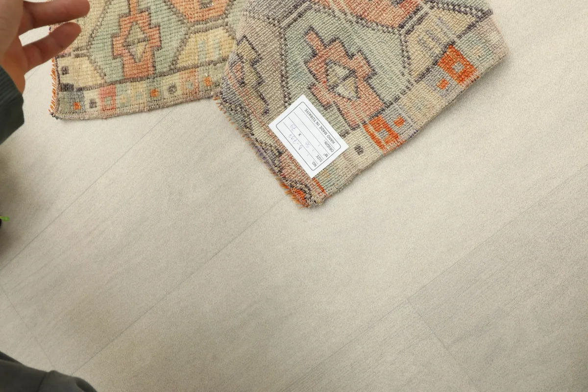 View of the rug's back, revealing the hand-knotted cotton foundation and wool pile structure.
