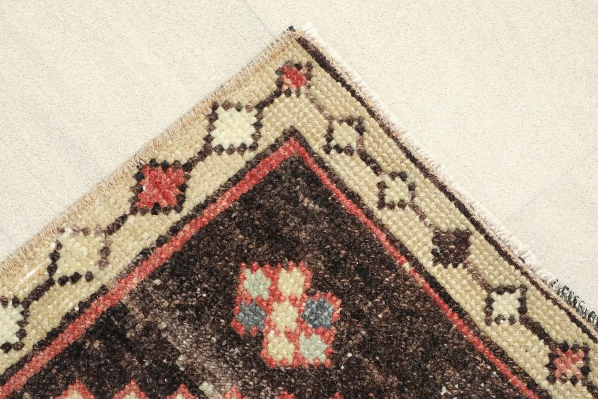 Corner detail showing the beige border with small geometric shapes and the black inner border.