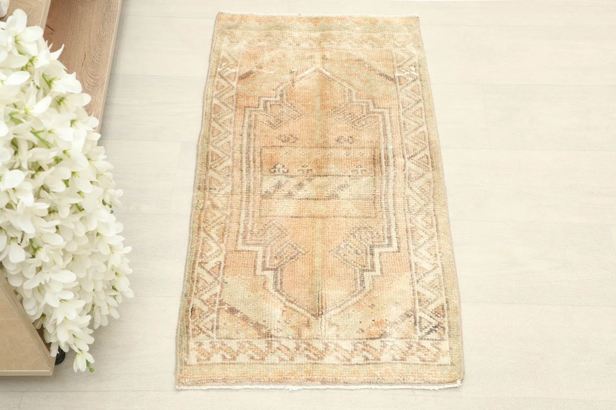 Overhead view showcasing the geometric and tribal patterns on the tan field of the rug