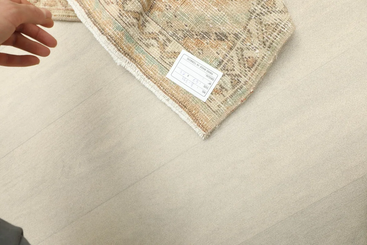 Corner of the rug with a close-up of the label, indicating its origin and materials