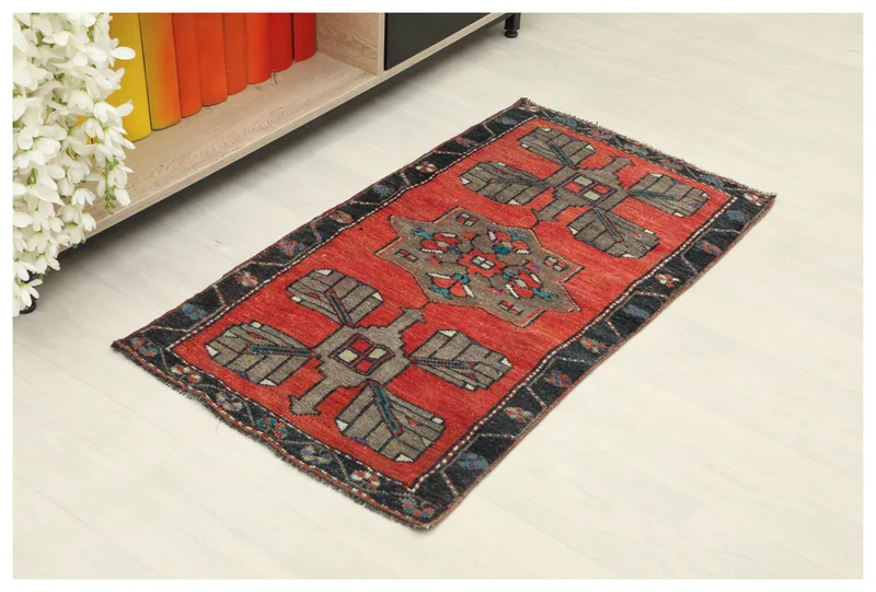 Full top view of a 1'10" x 3'4" vintage red Anatolian wool rug with geometric brown and gray patterns on a white background.
