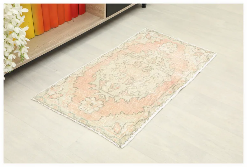 Full top view of the 1'8" x 3'1" rose and beige vintage Anatolian rug on a light floor.