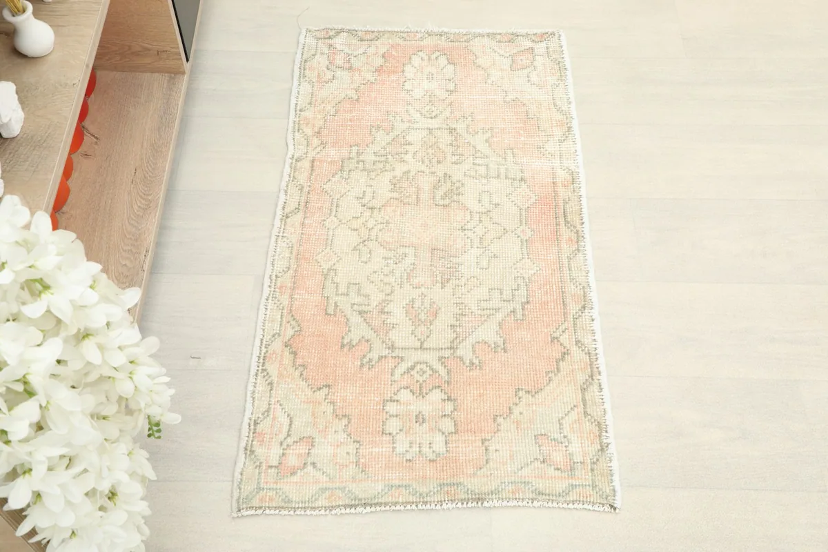 Overhead view of the hand-knotted rose and beige rug, showcasing its full pattern and colors.