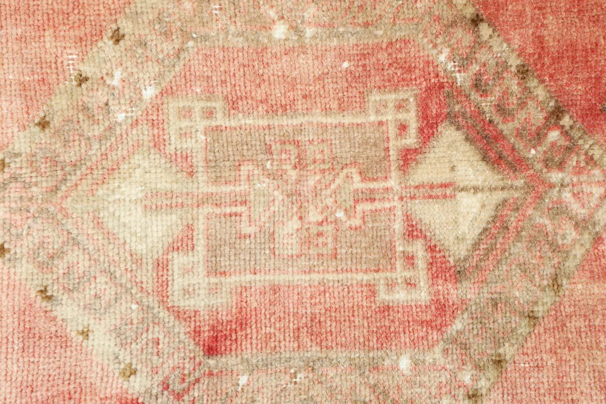 Detailed view of the rug's central tribal motif and the texture of the hand-knotted wool pile.