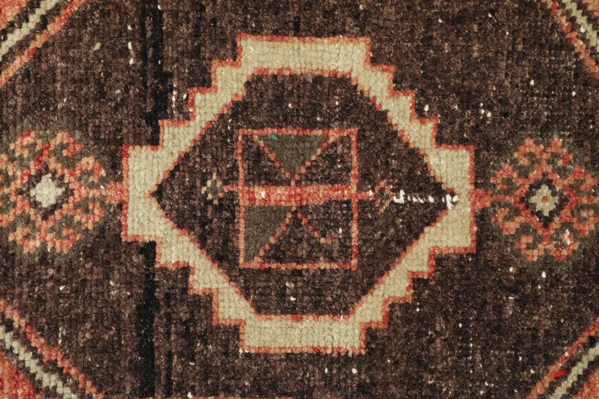 Detailed view of the intricate geometric design within the central medallion, highlighting the wool pile.