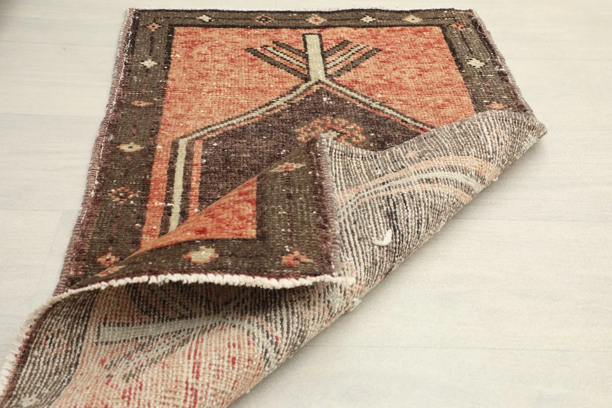 View of the doormat partially folded, revealing the reverse side and the construction of the rug.