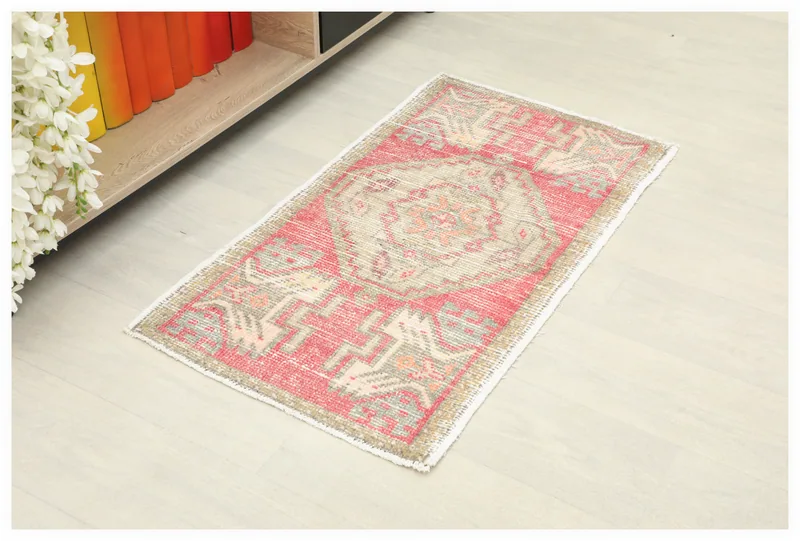 Full top view of the vintage rose Anatolian doormat rug on a white background