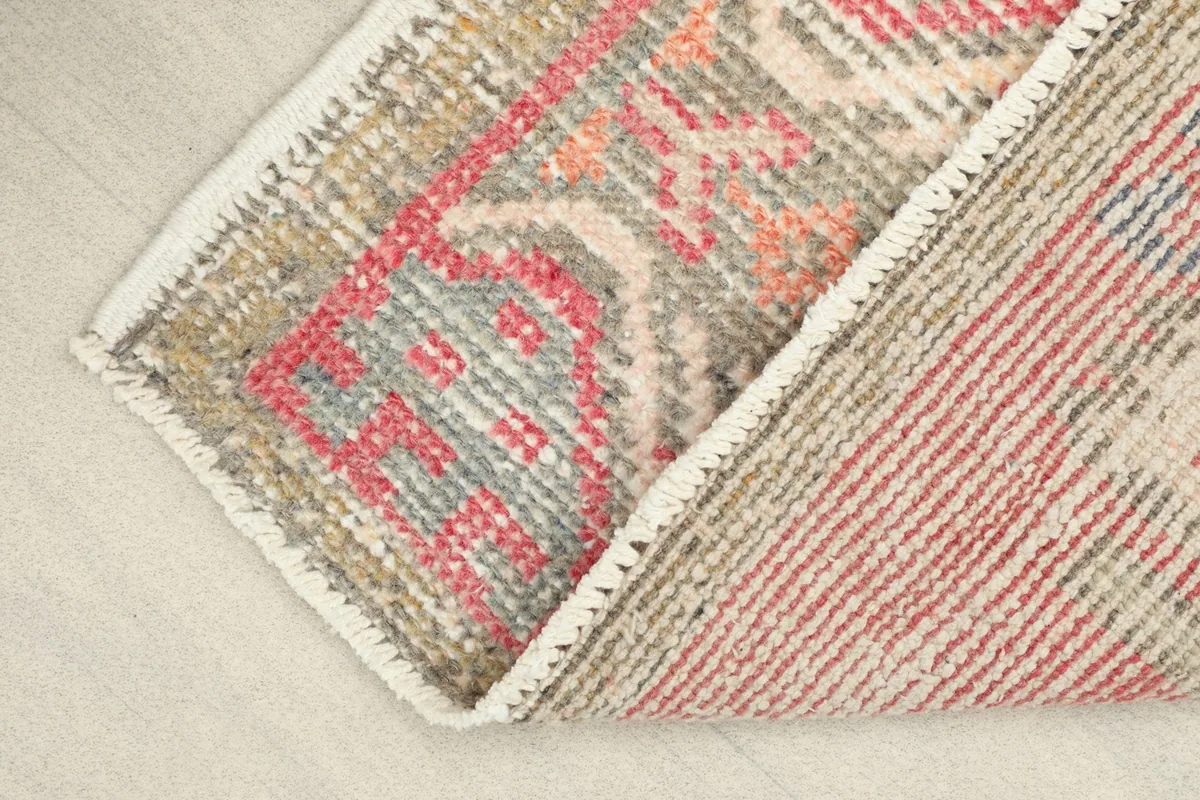 View showing the low pile texture and the cotton foundation on the back of the rug