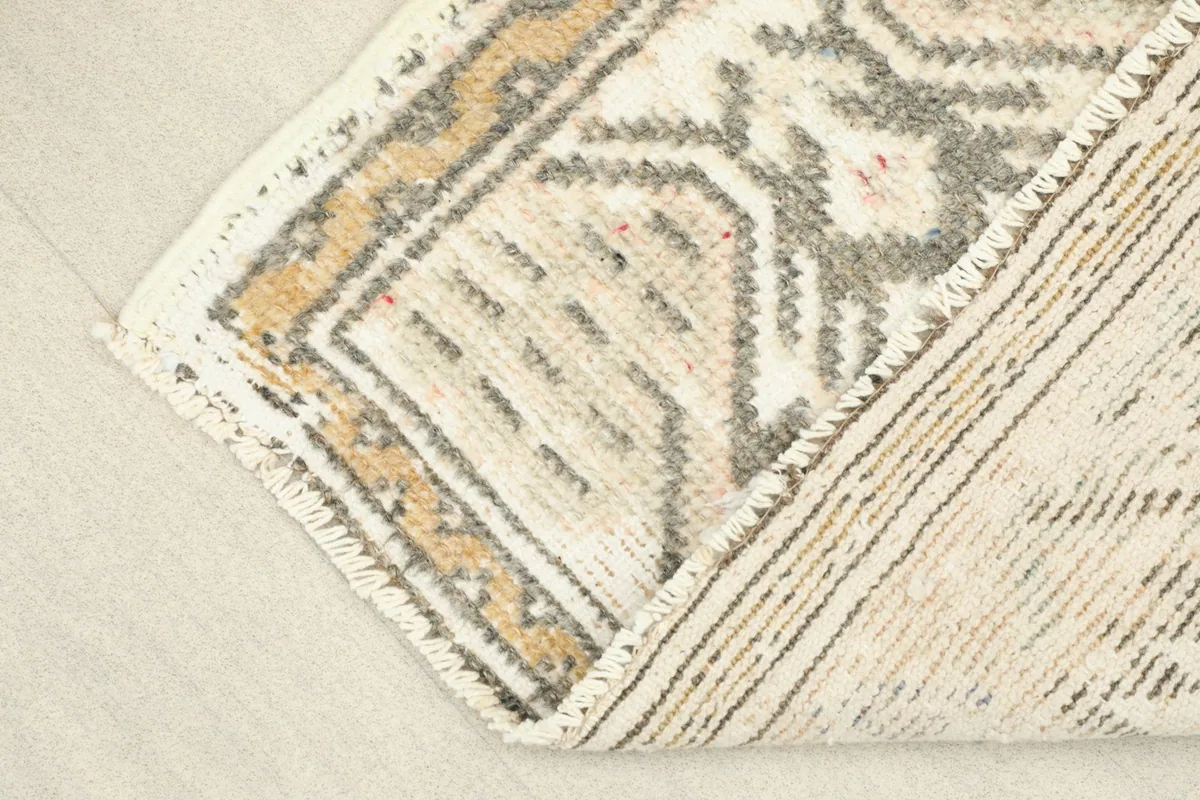 View showing the low pile texture and the hand-knotted construction of the vintage wool rug.