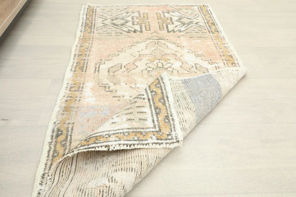 Angled view of the rug with a corner folded over, revealing the cotton foundation.
