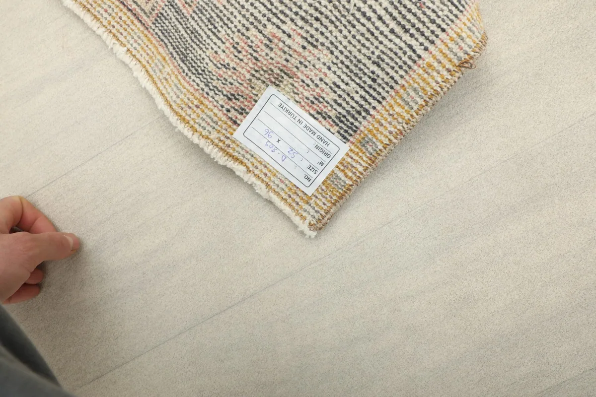 Close-up of the back of the vintage Anatolian rug, displaying the hand-knotted construction and care label.
