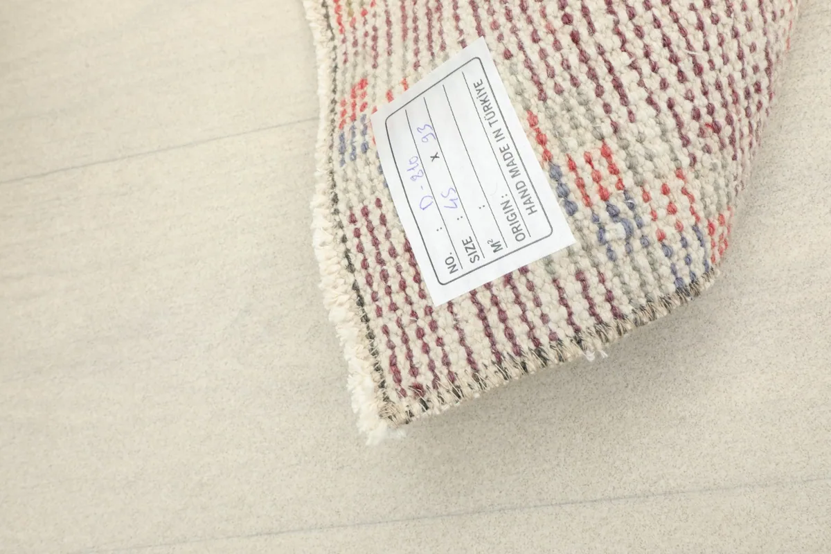 Close-up of the rug's back with a label indicating origin and dimensions, confirming it is hand-made in Turkey.