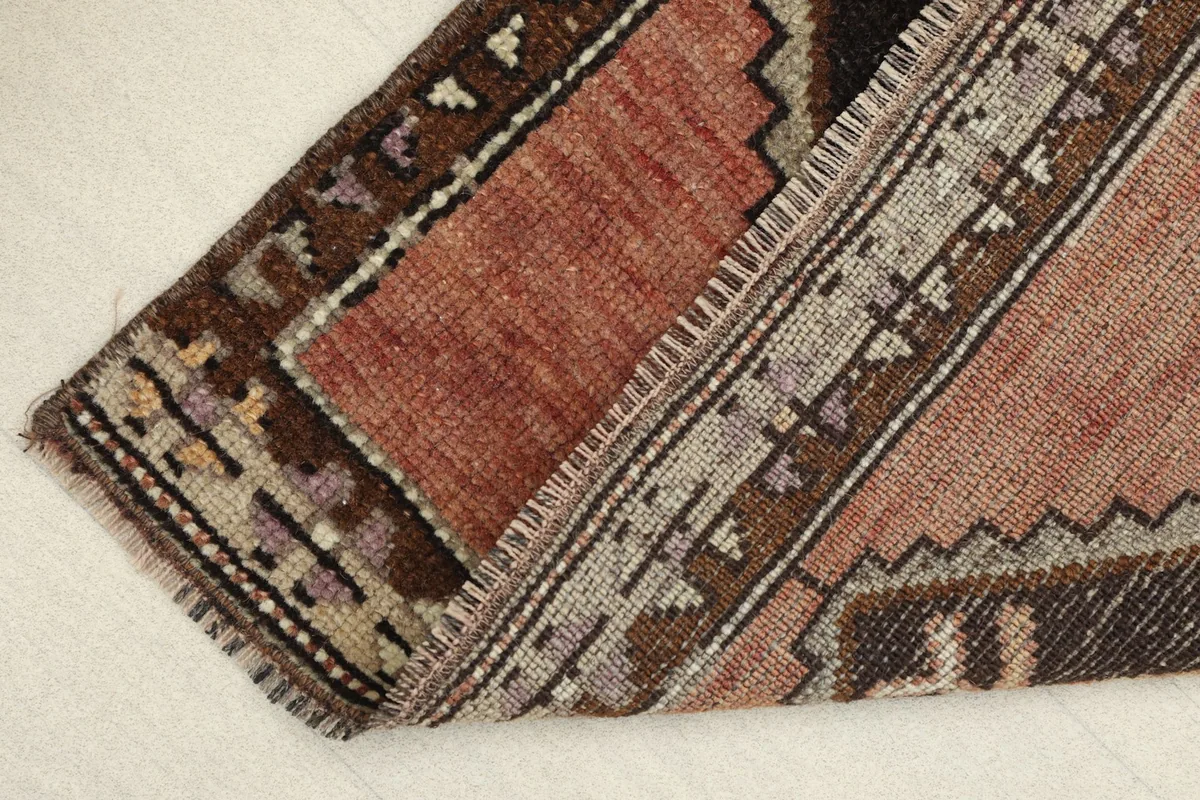 View of the rug folded to show the thickness and flexibility of the vintage hand-knotted wool on cotton foundation.