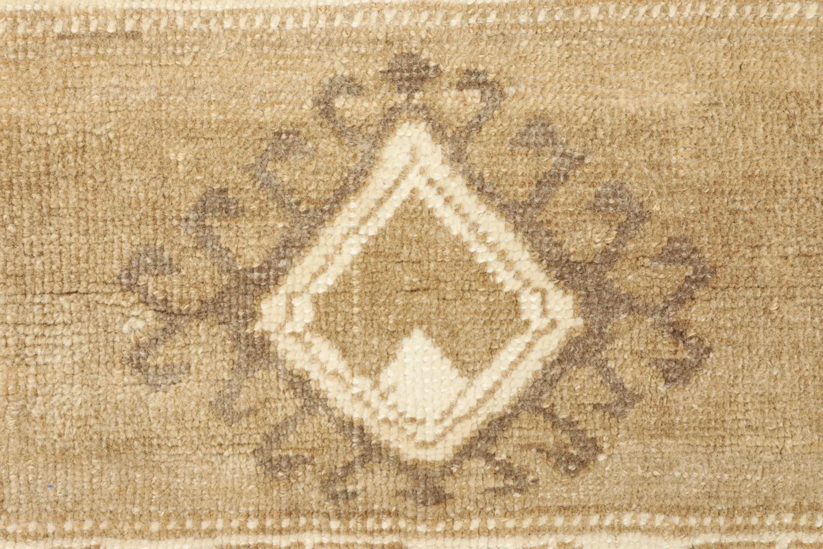 Detailed view of a central geometric medallion with brown and ivory accents