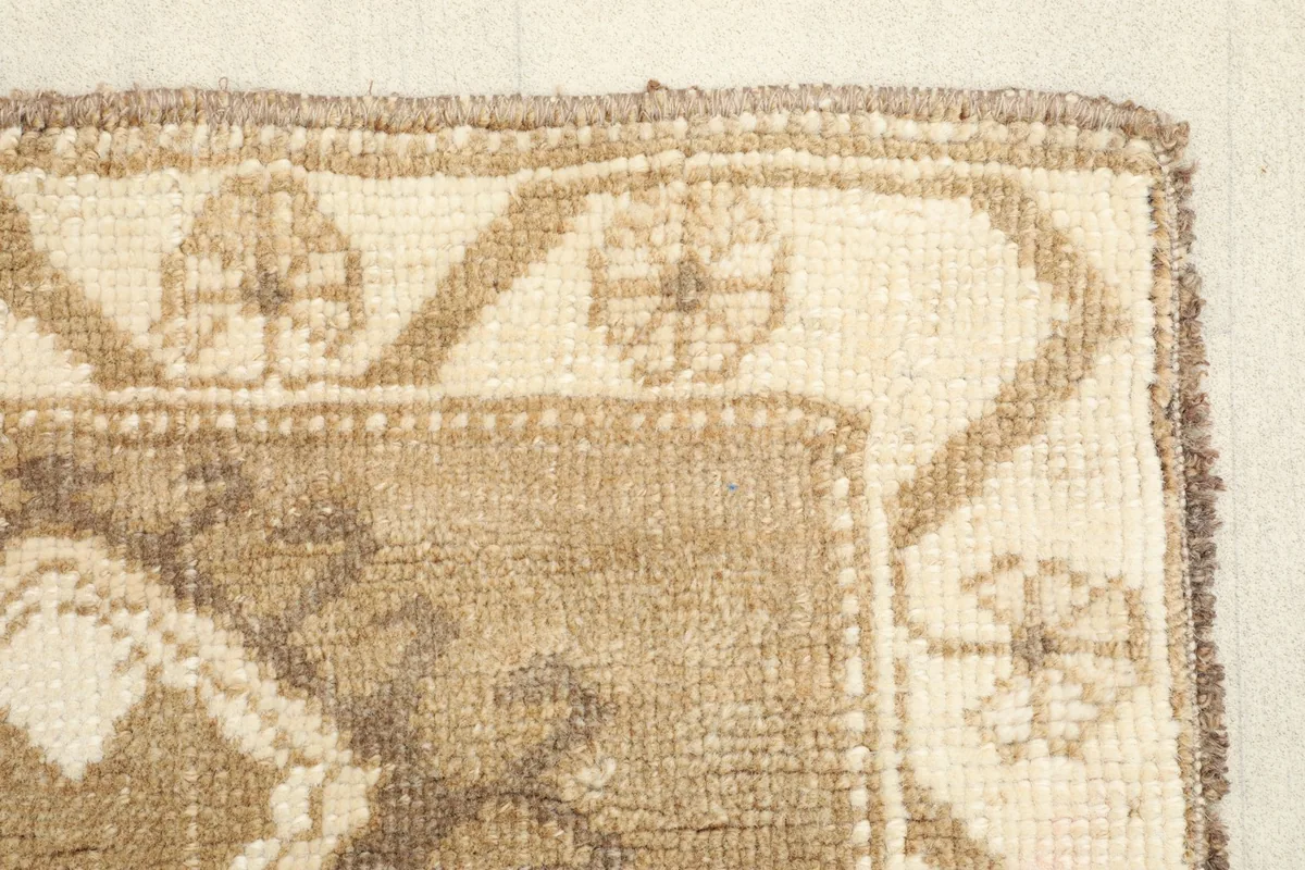 Close-up on the corner of the rug, detailing the hand-knotted pile and border pattern