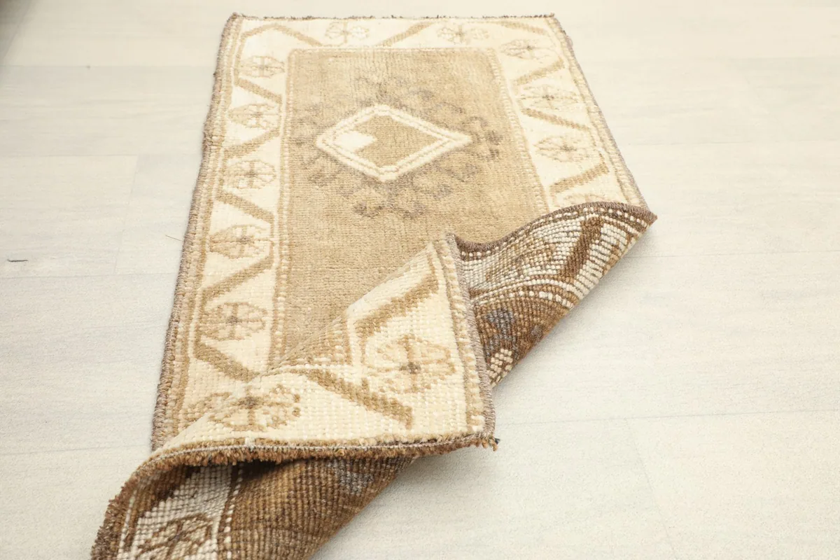 The small rug partially folded, showcasing its flexibility and construction