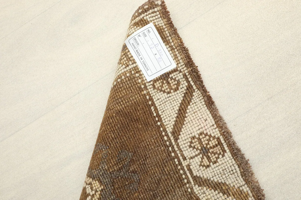 Underside of the rug with a label, revealing the rich brown tones of the foundation