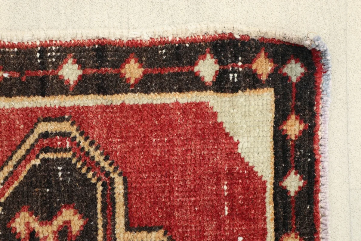 Close-up of the rug's edge, revealing the hand-knotted texture and color variations.