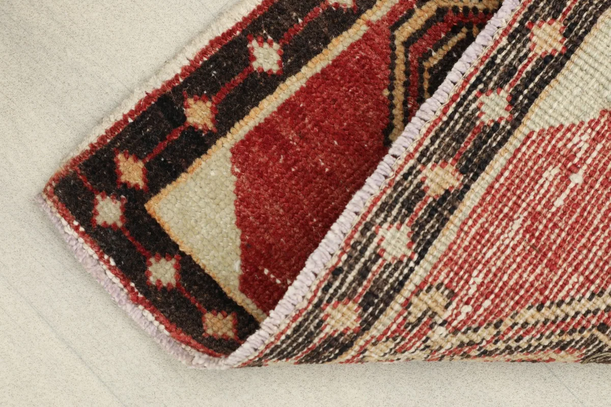 View of the rug's low pile and cotton foundation, showing its vintage character.