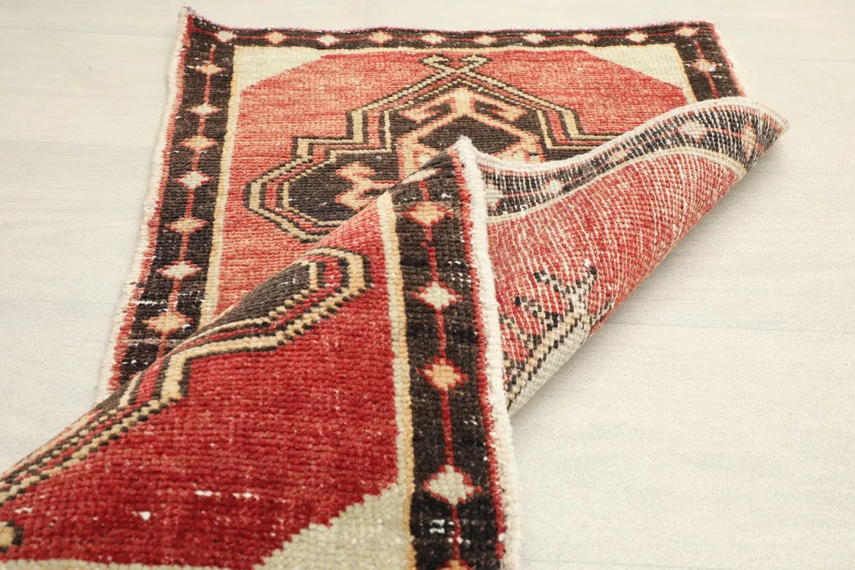 Partial view of the rug's back, revealing the hand-knotted construction and fringe.