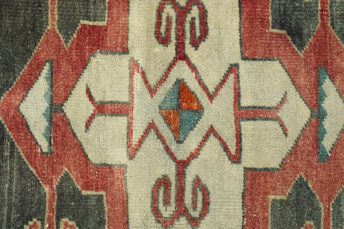 Close-up detail of the central cream and red geometric pattern with blue and orange accents.
