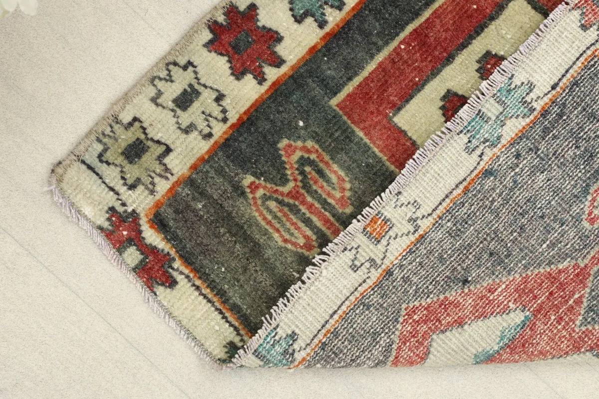 View of the low pile and texture of the hand-knotted wool, with a partial fold.