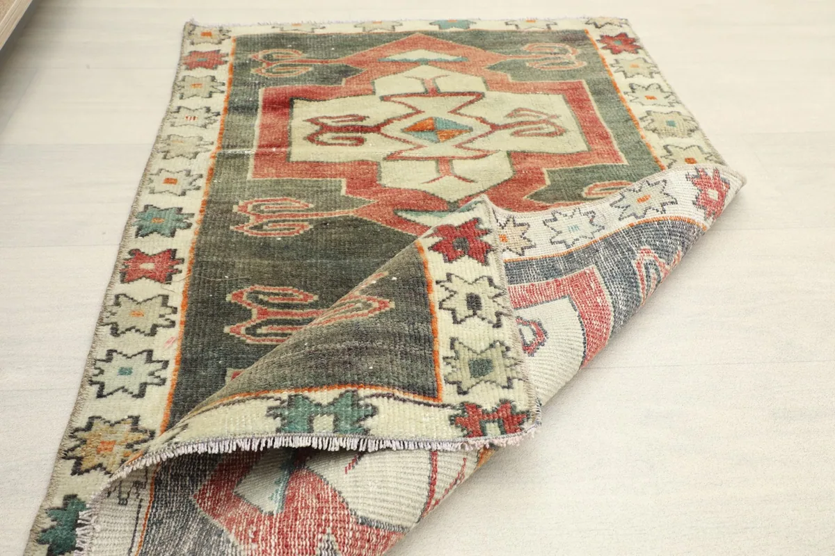 The rug partially folded, showing the flexibility and construction from an angled perspective.