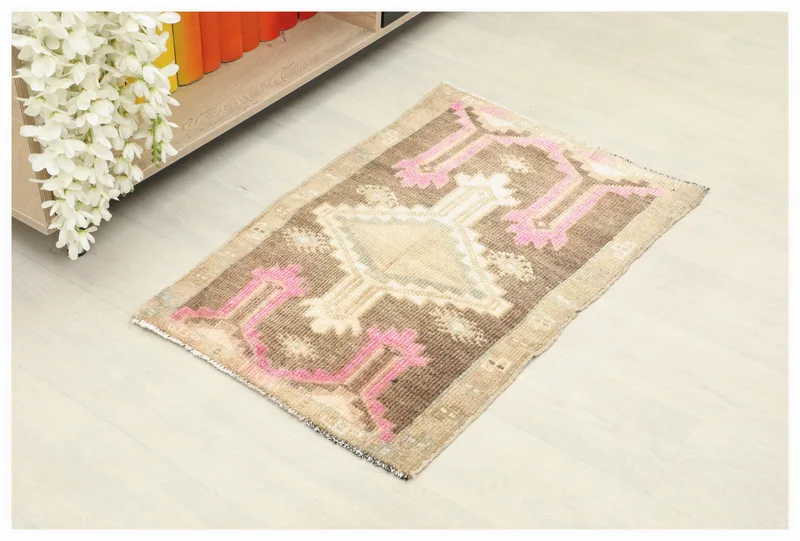 Full top view of the brown and pink geometric vintage Anatolian wool rug on a white background.