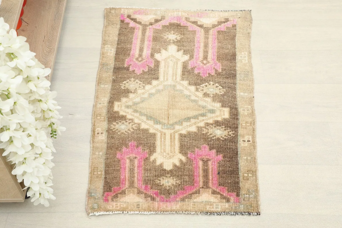 Direct overhead view showcasing the complete pattern and colors of the brown and pink vintage rug.