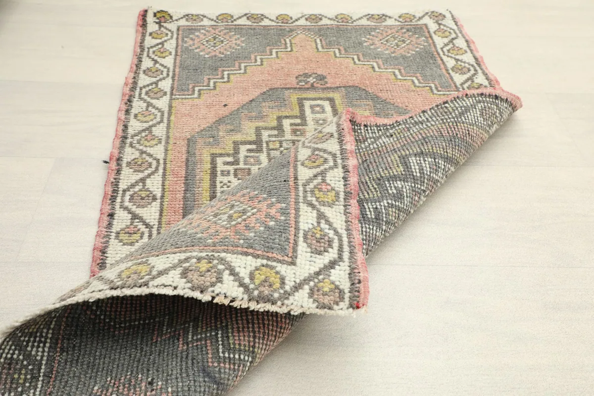 Partially folded rug displaying the back weave and the rich, varied colors of the knots.