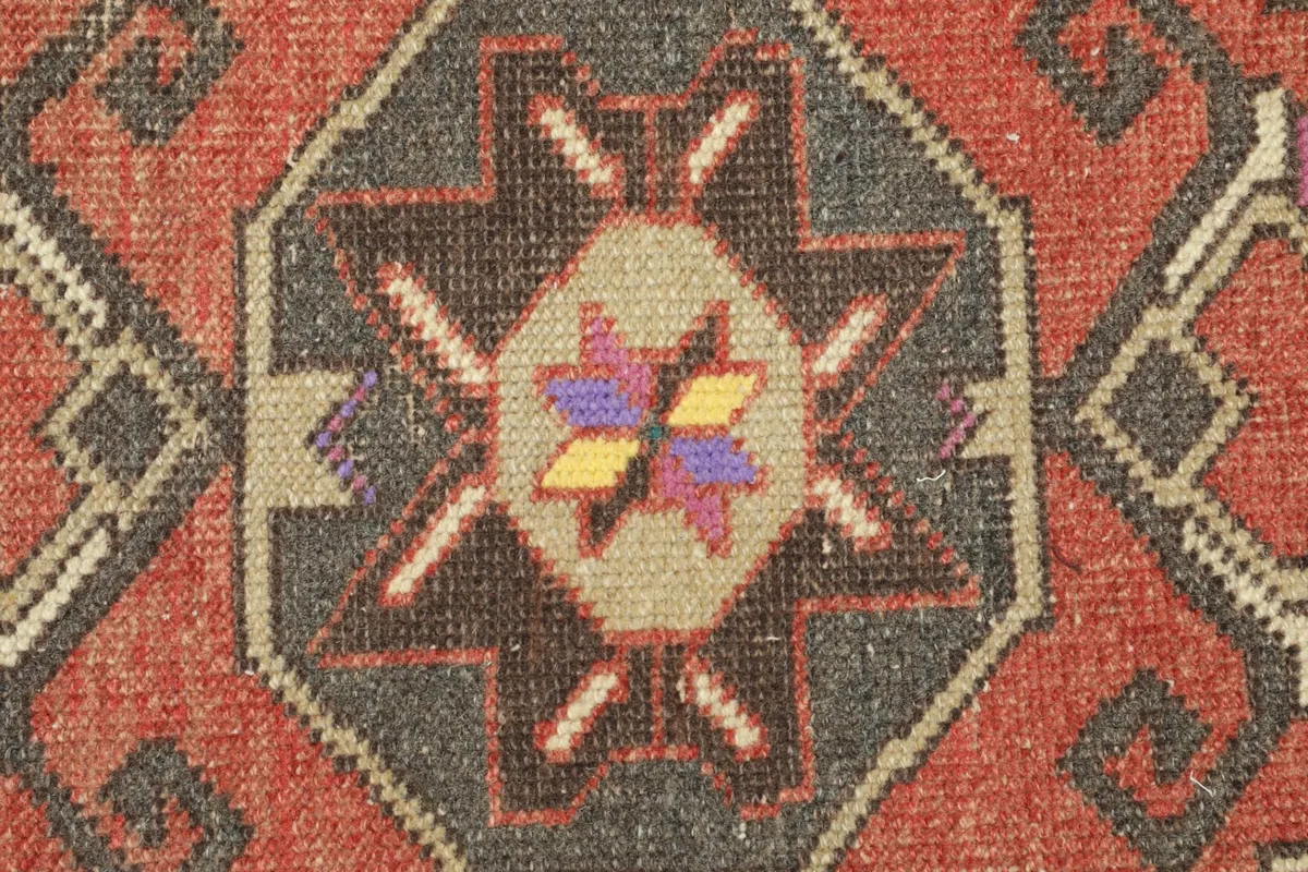 Detailed close-up showing the intricate hand-knotted wool pile and color variations in the central motif.