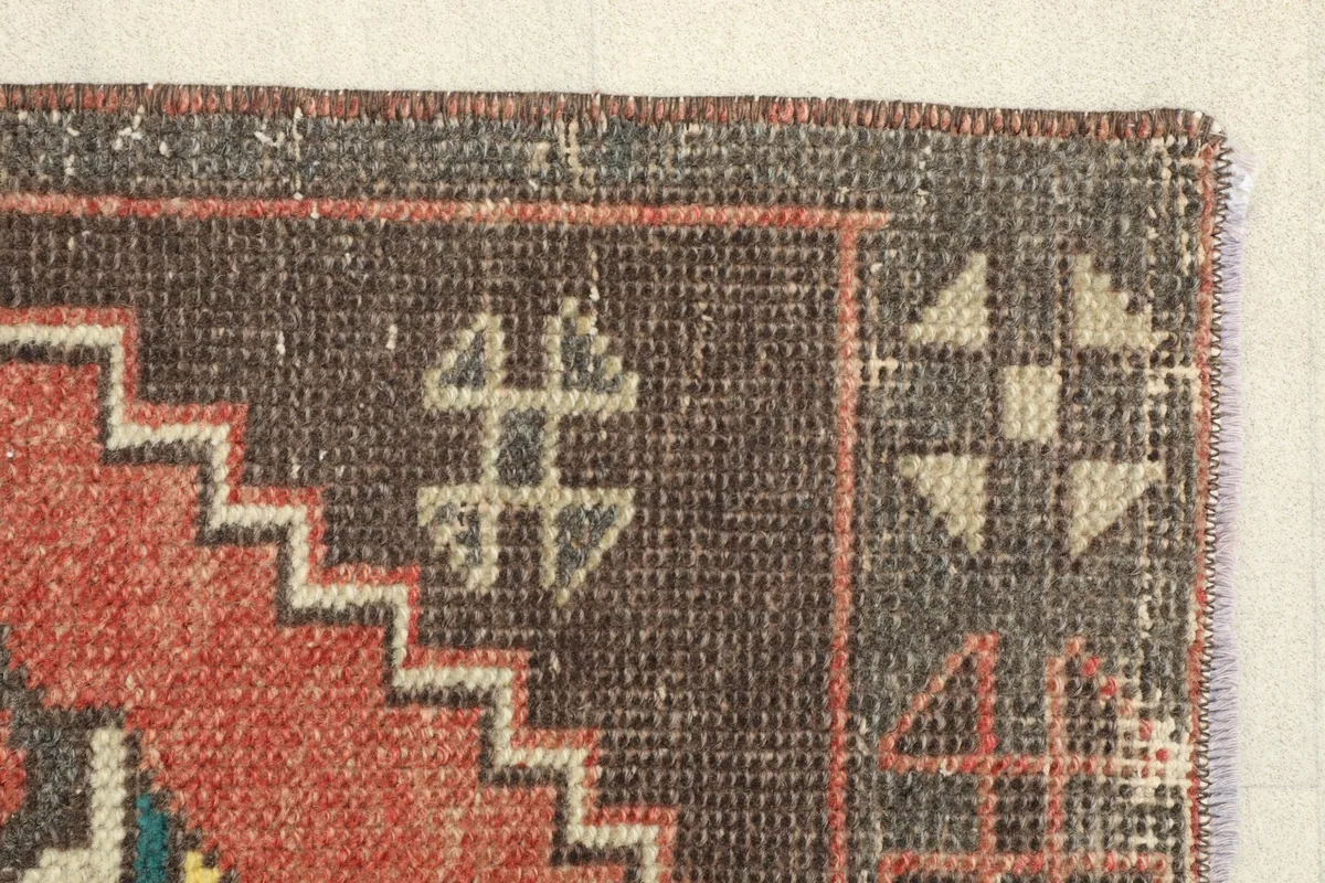 Close-up of another corner, revealing the worn edges and the texture of the hand-knotted pile.