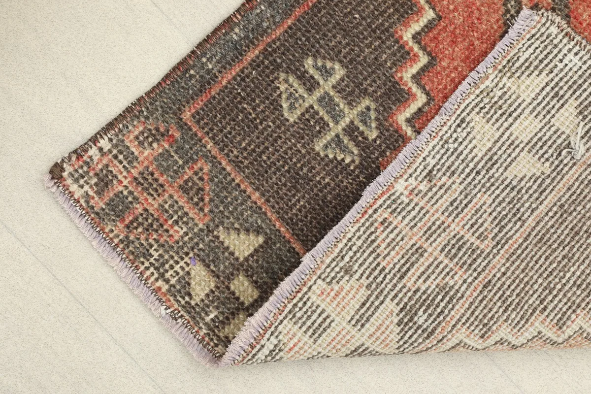 View showing a corner of the rug folded back, revealing the cotton foundation and the reverse side.