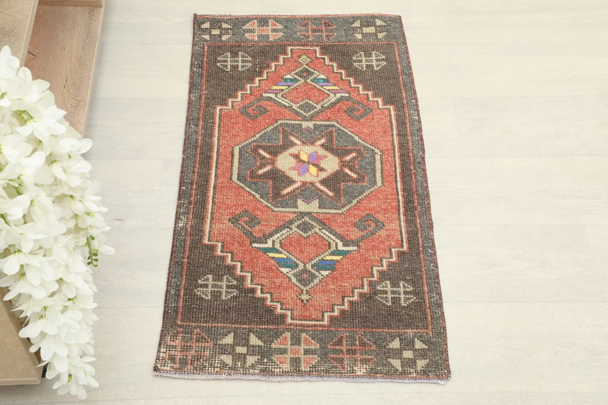 Overhead view of the rust doormat, highlighting its geometric patterns and charcoal border.