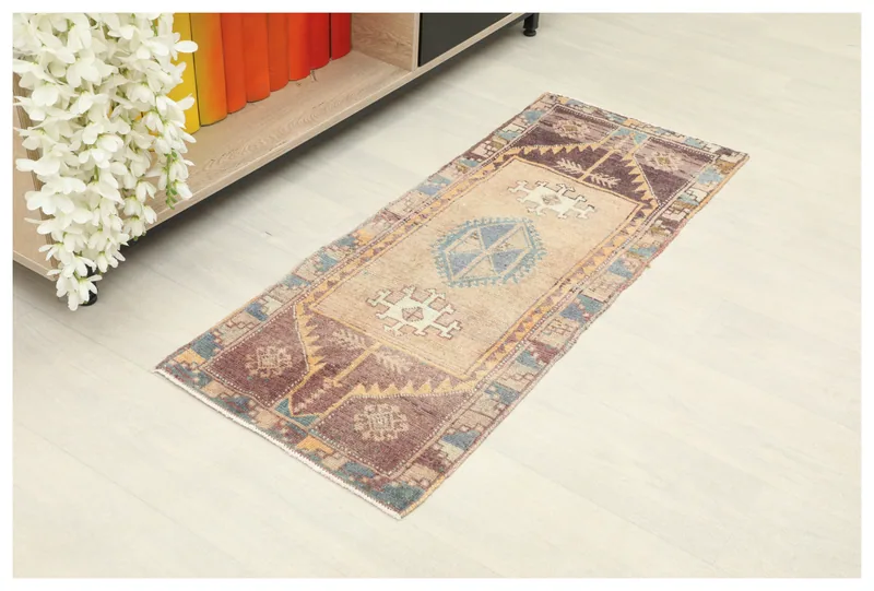 Full top view of the 1'5" x 3'7" vintage Anatolian runner rug with geometric patterns on a tan field.