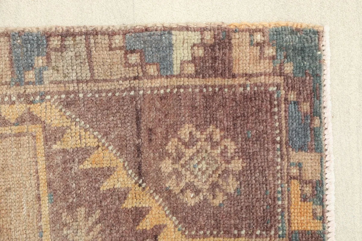 Close-up of the tribal patterns and colors in the border and main field transition of the vintage runner.