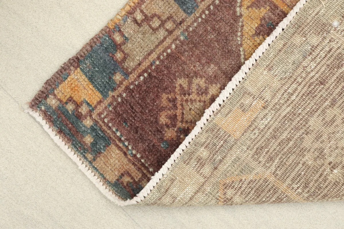 View of the back of the hand-knotted wool rug, revealing the cotton foundation and craftsmanship.