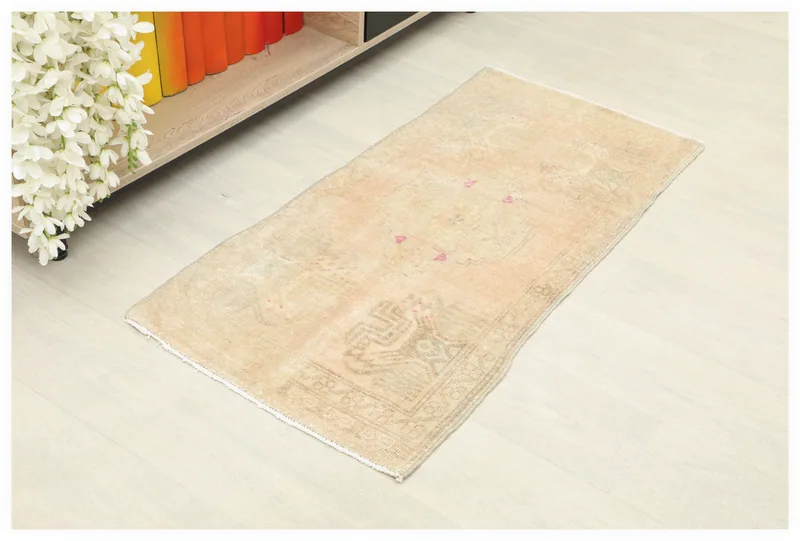 Full top view of the beige and rose vintage Anatolian doormat on a white background.