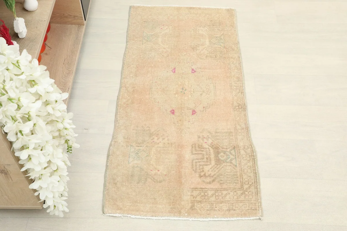 Overhead view of the hand-knotted doormat, highlighting its rectangular shape and soft colors.
