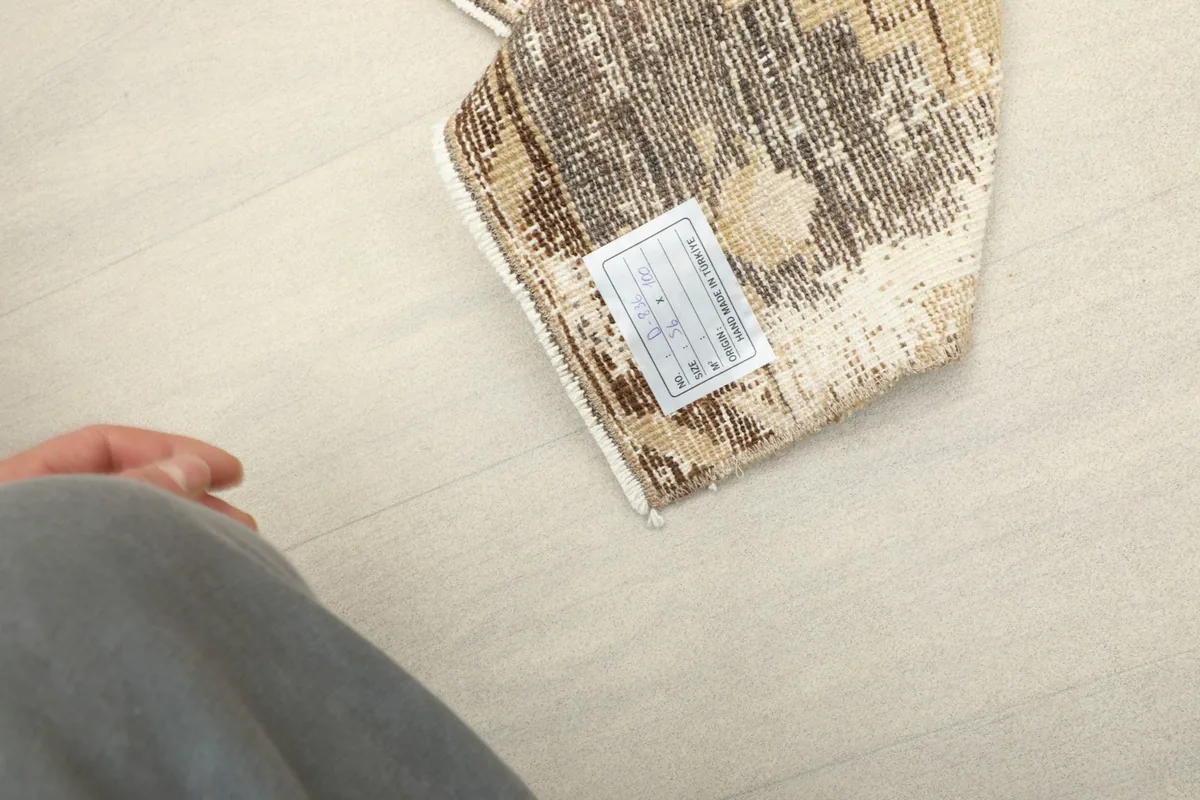 Close-up of the back of the rug, revealing the woven cotton foundation and a product label.
